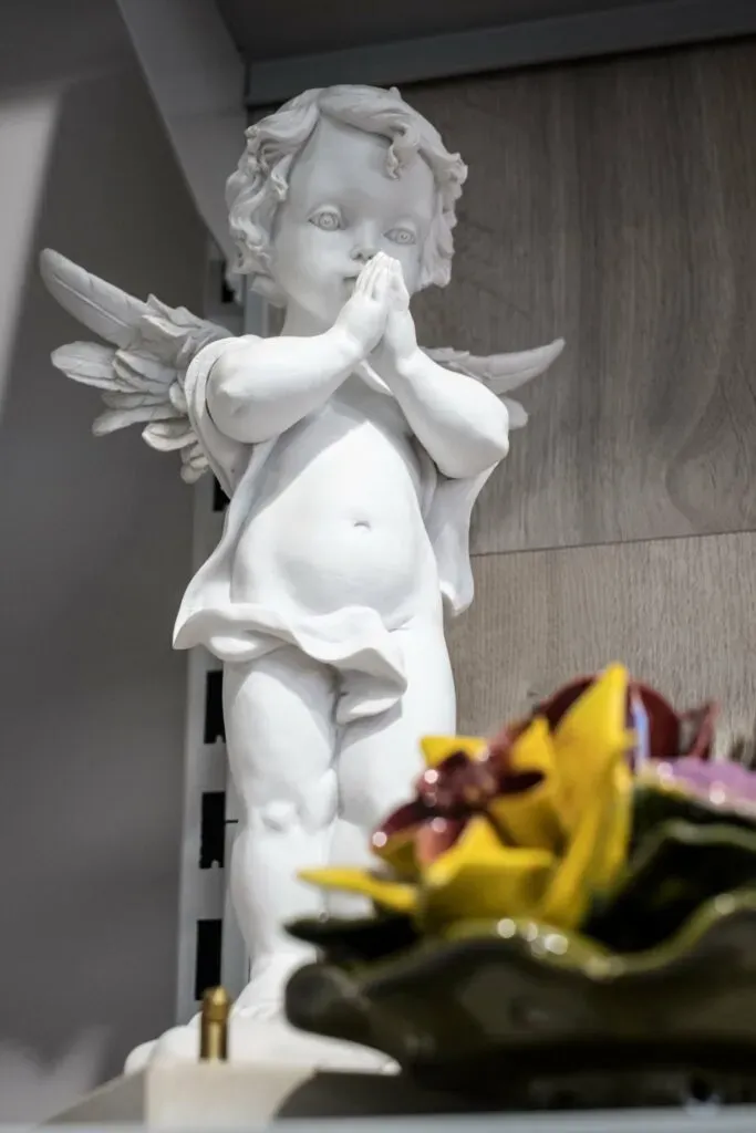 Statue funéraire en forme d'ange blanc en prière.